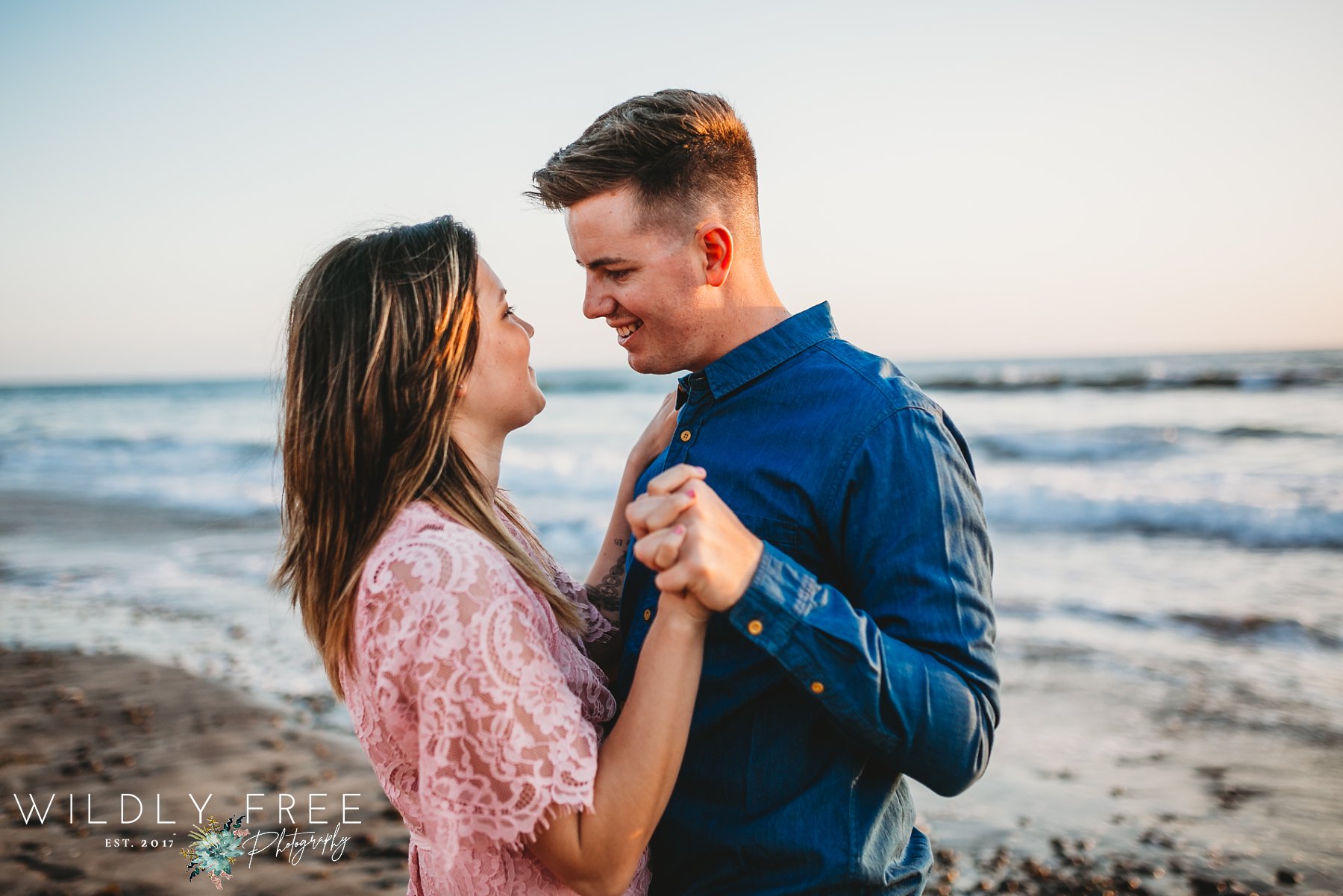 Engaged couple dancing on beach at Torrey Pines CA